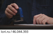 Close-up of a man's hands signing an official document and putting a seal. unrecognizable businessman signs a contract on his desktop. concept of document management. front view. Стоковое видео, видеограф ЛУНИНА ВЕРОНИКА / Фотобанк Лори
