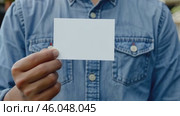 Male hand holds an empty white business card. Clean blank flyer in businessman hands. For your text. Business Communication Company Entrepreneur Concept. Man holding showing white single business card. Стоковое AI-видео, аниматор Марина Демидюк / Фотобанк Лори