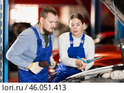 Car service manager discusses car repair problems with mechanic. He takes notes on paper. Стоковое фото, фотограф Яков Филимонов / Фотобанк Лори