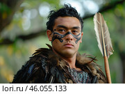 Maori warrior wearing traditional clothing and ta moko posing with spear. Стоковое AI-изображение, AI-художник Иван Рябоконь / Фотобанк Лори