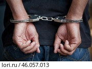 Detained criminal with his hands in handcuffs. Стоковое AI-изображение, AI-художник Дмитрий Киселёв / Фотобанк Лори