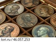Antique bronze coins with portraits of presidents in a collection box. Numismatics is the study of coins. Стоковое AI-изображение, AI-художник Иван Рябоконь / Фотобанк Лори
