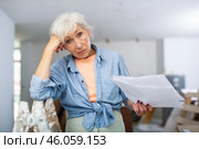 Elderly woman owner is shocked by the estimate for the renovation of cottage. Стоковое фото, фотограф Яков Филимонов / Фотобанк Лори