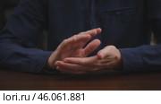An unrecognizable businessman in a blue shirt sits at a table and claps his hands with approval. applause for a new achievement, a victory. business concept of success. close-up. Стоковое видео, видеограф ЛУНИНА ВЕРОНИКА / Фотобанк Лори