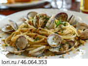 Delicious linguine with clams, grated cheese, and parsley sprinkled on top. Стоковое AI-изображение, AI-художник Иван Рябоконь / Фотобанк Лори