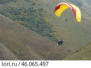 Russia, Kabardino-Balkaria, September 27, 2024: flight of a passenger with an instructor on a paraglider over the picturesque Chegemsky gorge. Стоковое фото, фотограф Роман Дзюбало / Фотобанк Лори