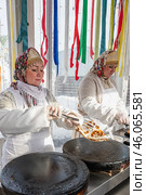 Kolomna, Russia, 17 March 2024. Pancakes with baking. Women in kokoshniks and national shawls bake pancakes. Celebrating Maslenitsa, a traditional Slavic holiday. Редакционное фото, фотограф Оксана Медведева / Фотобанк Лори