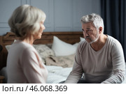Senior couple arguing on bed, resentment and relationship problems. Стоковое AI-изображение, AI-художник Иван Рябоконь / Фотобанк Лори