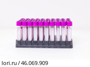 A rack of vacuum venipuncture test tubes for blood samples isolated on a while background. Medical treatment, laboratory concept. Стоковое фото, фотограф Ирина Михайличенко / Фотобанк Лори