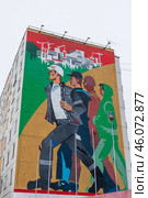 Город Тында, Амурская область, Россия. Вид на большое граффити на стене жилого дома, посвящённое строителям Байкало-Амурской магистрали (БАМ) и города Тынды. Красивый мурал с изображением молодых энергичных людей, идущих на стройку. (2024 год). Редакционное фото, фотограф Андрей Степанов / Фотобанк Лори