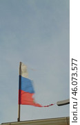 A weathered Russian flag against a clear blue sky. The flag is tattered and faded. The flag is flying in the wind and the pole is slightly tilted to the side. Стоковое видео, видеограф Воловодов Владимир / Фотобанк Лори