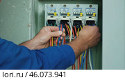 Male electrician working in switchboard with electrical connecting cable. Work in repair shops and maintenance services. Stress, nerves. Стоковое видео, видеограф ALLA YURTAYEVA / Фотобанк Лори