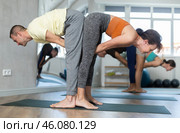 Women and men performing paired yoga exercises during group training at gym. Fitness and pair Hatha yoga concept. Стоковое фото, фотограф Яков Филимонов / Фотобанк Лори