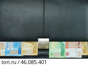 Фон. Черный кожаный портфель с металлическим замком. Российские денежные купюры торчат из-под крышки. Стоковое фото, фотограф Цибаев Алексей / Фотобанк Лори