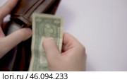 Financial difficulties. A man puts his last dollar in an empty wallet. Стоковое видео, видеограф Владимир Федоров / Фотобанк Лори