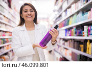 Cheerful saleswoman offering hair care products in cosmetic shop. Стоковое фото, фотограф Татьяна Яцевич / Фотобанк Лори