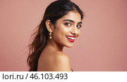 Close up portrait of beautiful Indian female model  with perfect glowy skin. Woman with beautiful brown hair and makeup posing in studio pink background showcasing happy expression. Стоковое AI-изображение, AI-художник Ирина / Фотобанк Лори