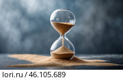 Sand flows steadily through an hourglass on a dark background creating an atmosphere of timelessness. Стоковое AI-изображение, AI-художник Сергей Толмачёв / Фотобанк Лори