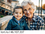 A happy family, a child and a grandmother hug on the street in the park, happy and contented. A grandmother who hugs her grandson, showing love. Стоковое AI-изображение, AI-художник Photojuli / Фотобанк Лори
