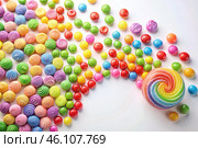 Colorful dragee candies in the assortment on a white background. Various sweets, confectionery and dragees of different shapes and colors. Bright rainbow hues. Стоковое AI-изображение, AI-художник Photojuli / Фотобанк Лори
