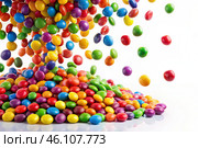 Colorful dragee candies in the assortment on a white background. Various sweets, confectionery and dragees of different shapes and colors. Bright rainbow hues. Стоковое AI-изображение, AI-художник Photojuli / Фотобанк Лори