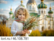 Christianity. Portrait of a three-year-old girl in a Russian folk shawl with a bouquet of wild grass in her hands against the background of an Orthodox church. Стоковое AI-изображение, AI-художник Photojuli / Фотобанк Лори