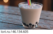 Refreshing Bubble Tea with Ice and Colorful Straw on Rustic Table. Стоковое видео, видеограф Данил Руденко / Фотобанк Лори