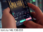 Businessman trader using smartphone checking stock exchange. Man using mobile phone with investing application. Stock market investment and trading cryptocurrency on app in hand. Online business data. Стоковое фото, фотограф Марина Демидюк / Фотобанк Лори