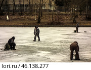 Зимняя рыбалка в черте города Москва/ Men ice fishing on a frozen lake. Men engaged in winter fishing on the lake in Moscow, Russia. Редакционное фото, фотограф Iva Noel / Фотобанк Лори