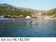 Canj, Montenegro 07.20.2024 Boats and a shore with vacationers, sunbathers and swimmers. Hotels, sun umbrellas, Adriatic waves, buoys. Beach tourism. Vacation travel. Summer day. Pebble rock beach. Редакционное фото, фотограф Юлия Петровская / Фотобанк Лори