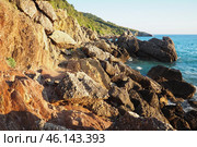 Waves gently crash against the rugged rocks while the sun sets over the horizon. Experience the serene beauty of this coastal location filled with natural wonders. Canj, Montenegro, Adriatic sea (2024 год). Стоковое фото, фотограф Юлия Петровская / Фотобанк Лори