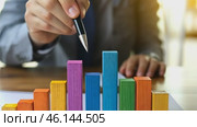 Person Holding a Pen Pointing Colorful Financial Charts, Analysis, Business Activities. Professional is Analyzing a Bar Graph, Data Trends, Report. Businessman Analyzing Document. Growth. Investment. Стоковое AI-видео, аниматор Марина Демидюк / Фотобанк Лори