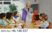 at evening geography lesson, elderly teacher tells attentive students about France. Стоковое видео, видеограф Яков Филимонов / Фотобанк Лори