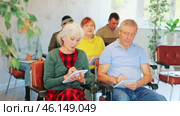 Focused motivated older woman and man listening to lecture in auditorium with group. Seniors education concept. Стоковое видео, видеограф Яков Филимонов / Фотобанк Лори