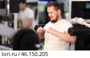 Bearded man in gym performs exercises for arm muscles using simulators and fitness center equipment. Стоковое видео, видеограф Яков Филимонов / Фотобанк Лори