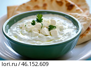 Traditional Greek Tzatziki dip sauce made with cucumber sour cream. Yogurt sauce with dill, lemon juice, olive oil. Served with toasted Za'atar Pita bread. Top view. Tarator, cacik or tartar. Стоковое AI-изображение, AI-художник Марина Демидюк / Фотобанк Лори