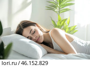Young woman sleeping in bed. Caucasian attractive girl hugging soft white pillow. Happy Lady enjoys fresh soft bedding linen, mattress in bedroom lying closed eyes. Good sleep concept. Sunny morning. Стоковое AI-изображение, AI-художник Марина Демидюк / Фотобанк Лори