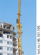 Строящееся высотное здание и подъемный кран на фоне голубого неба. Building crane and building under construction against blue sky. Стоковое фото, фотограф Татьяна Д / Фотобанк Лори