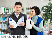 Female consultant helps man buyer choose laundry fabric softener. Стоковое фото, фотограф Яков Филимонов / Фотобанк Лори