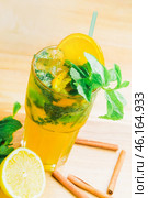 Refreshingly vibrant citrus mint drink served in a glass with lemon and mint garnishes on a wooden surface. Стоковое фото, фотограф Сергей Толмачёв / Фотобанк Лори