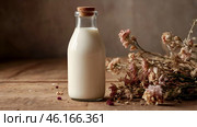 Organic natural oat milk in a glass bottle on a stylish wooden board and plants. Natural, environmentally friendly products. Стоковое AI-изображение, AI-художник Photojuli / Фотобанк Лори