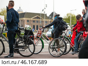 AMSTERDAM, THE NETHERLANDS - APRIL 16, 2019: Cyclists on bicycles wait for a green traffic light. Редакционное фото, фотограф Irina Kuchugurina/Gaudy / Фотобанк Лори