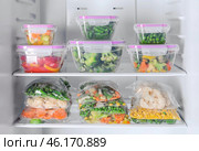 Containers and plastic bags with frozen vegetables in refrigerator. Стоковое фото, фотограф Pixel_shot / Фотобанк Лори