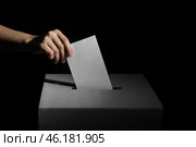 Voting woman near ballot box on dark background. Стоковое фото, фотограф Pixel_shot / Фотобанк Лори