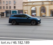 BMW iX EV car moving on the street. Modern crossover SUV driving along street in city with blurred background. Редакционное фото, фотограф Константин Григорьев / Фотобанк Лори