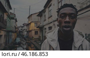 Young rapper singing in a poor neighborhood. Стоковое видео, видеограф Данил Руденко / Фотобанк Лори