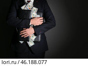 Businessman holding briefcase with dollar banknotes on dark background. Corruption concept. Стоковое фото, фотограф Pixel_shot / Фотобанк Лори