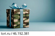 The concept of Defender of the Fatherland Day on February 23. Gift camouflage box with a festive satin ribbon bow on a light blue background. Стоковое AI-изображение, AI-художник Photojuli / Фотобанк Лори