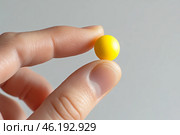 Yellow ball balanced on a fingertip against a dark background during daylight. Стоковое AI-изображение, AI-художник Юлия Гапеенко / Фотобанк Лори