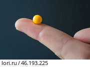 Yellow ball balanced on a fingertip against a dark background during daylight. Стоковое AI-изображение, AI-художник Юлия Гапеенко / Фотобанк Лори